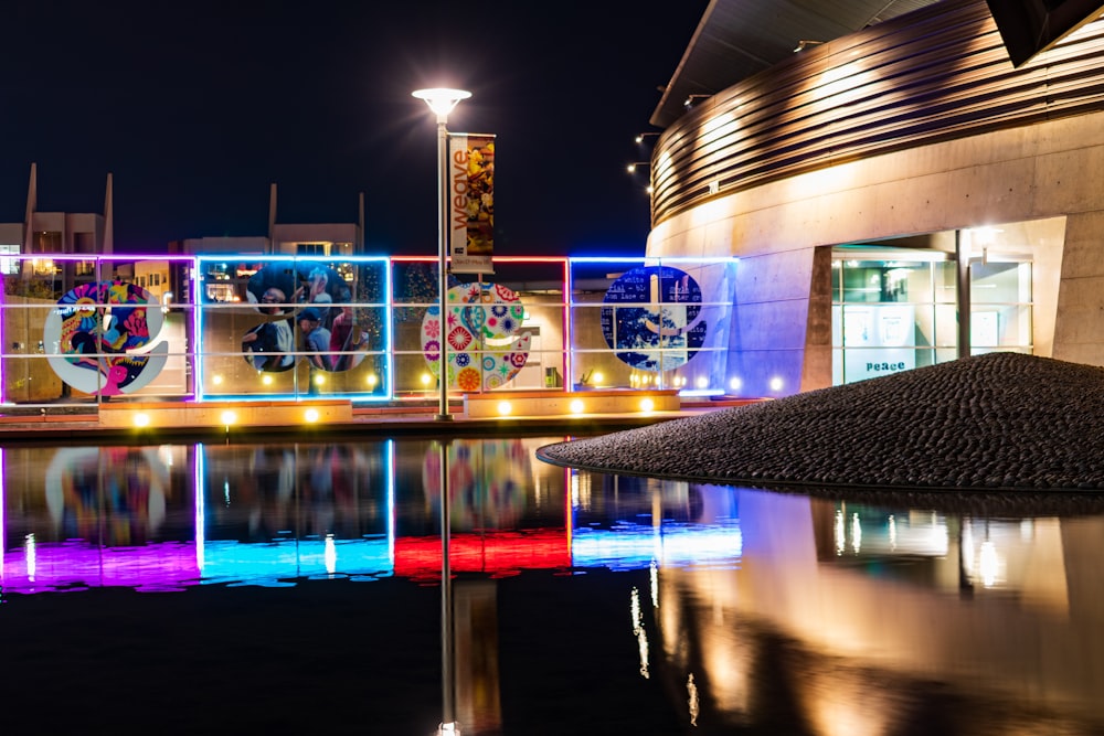 lighted building near body of water during night time