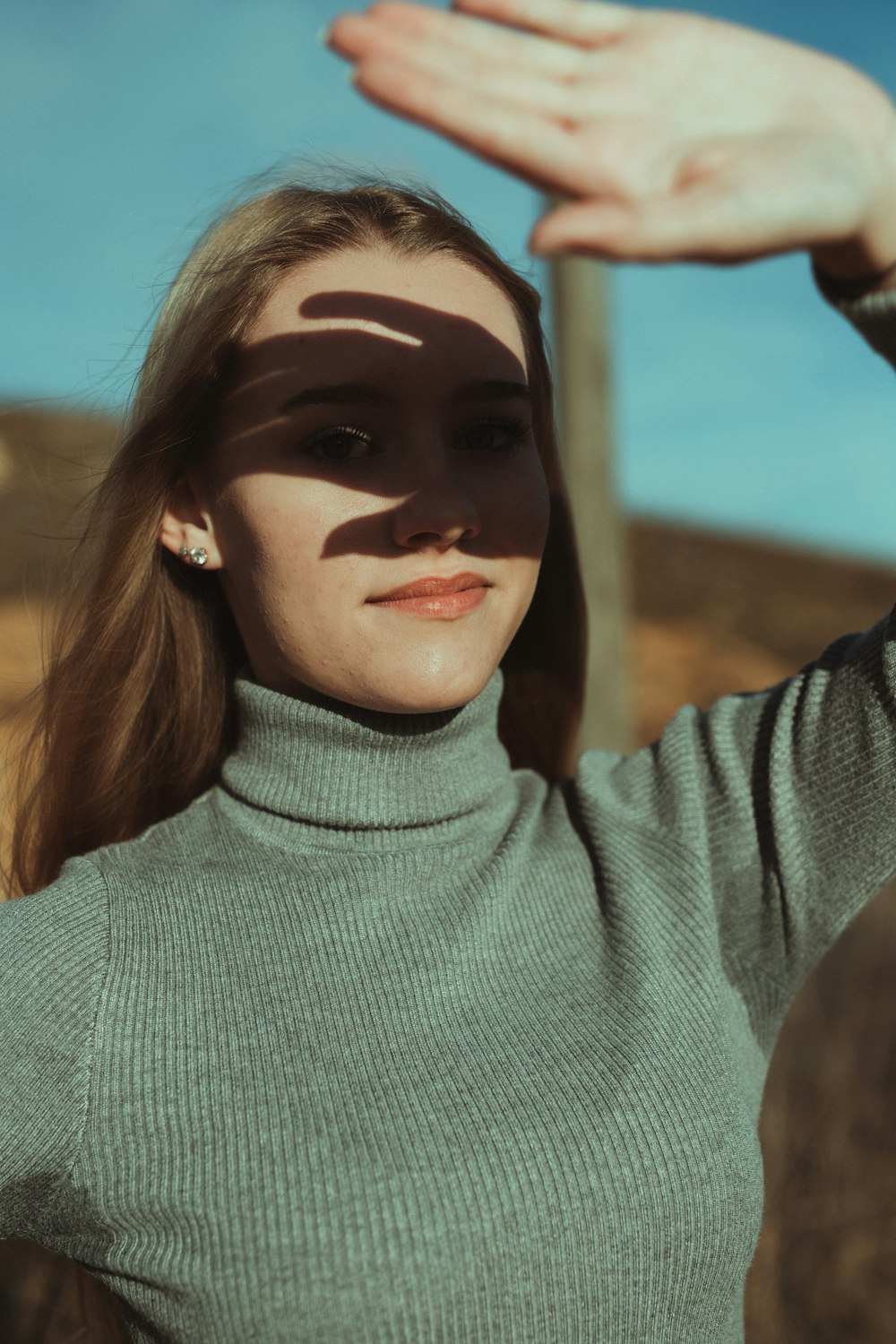 Femme en pull à col roulé vert avec peinture pour le visage