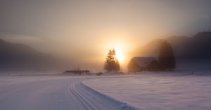 snow covered field during sunset