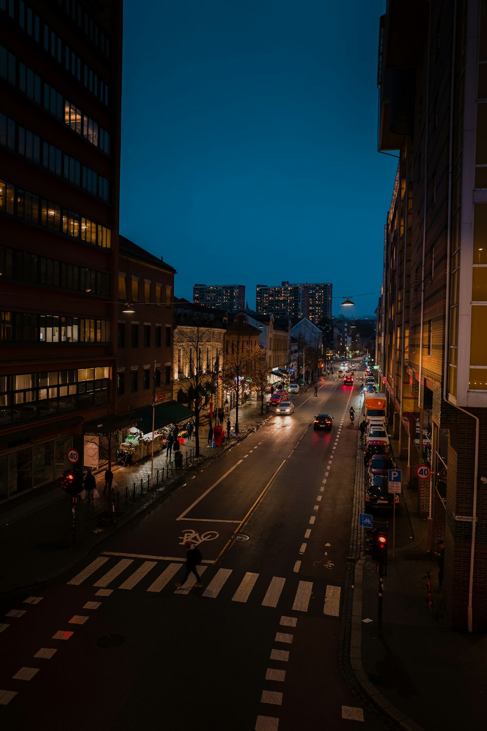 cars on road between high rise buildings during night time