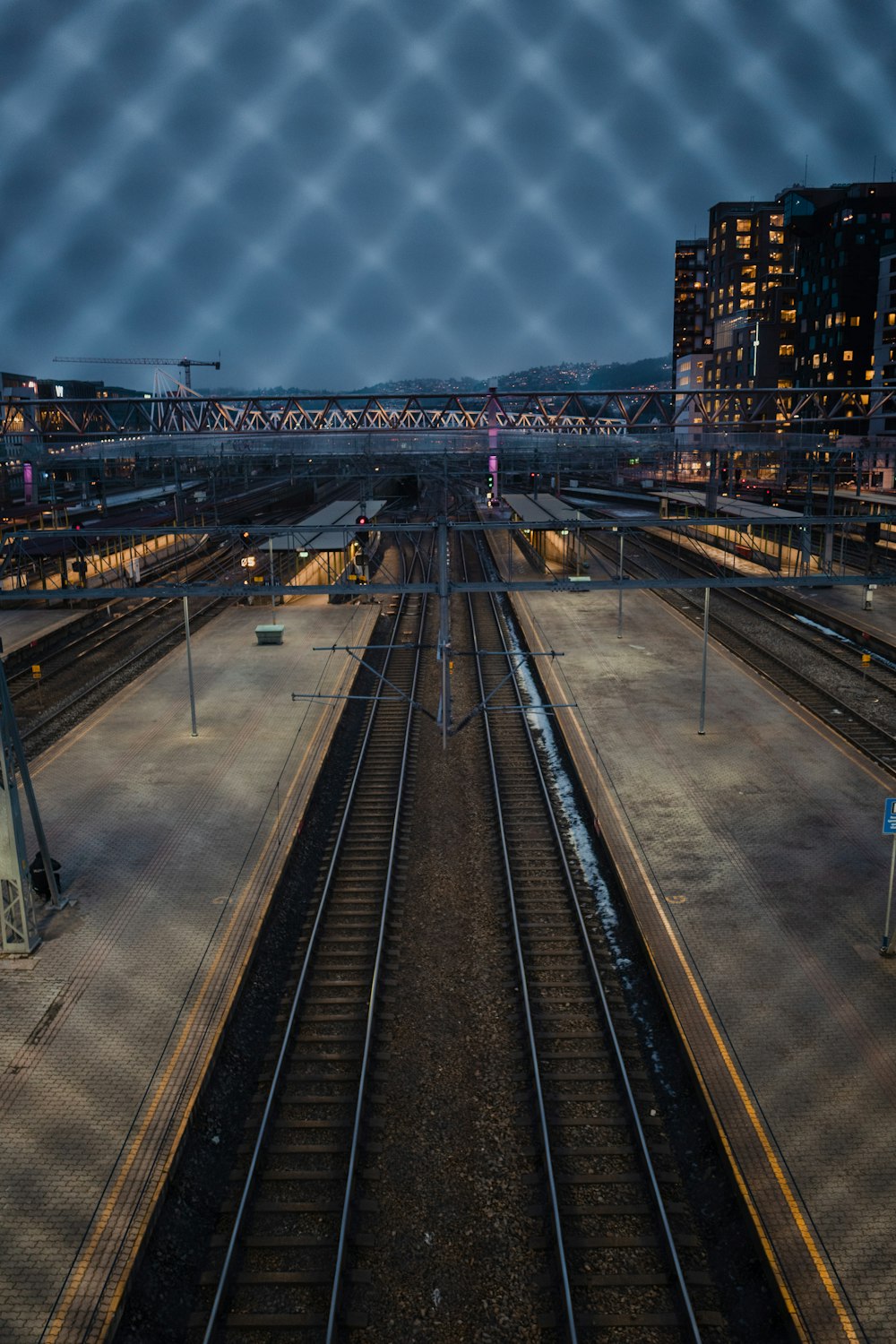 train rail near city buildings during night time