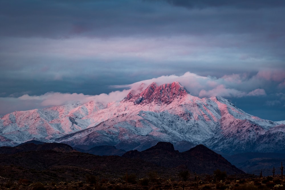 montagne enneigée sous un ciel nuageux pendant la journée