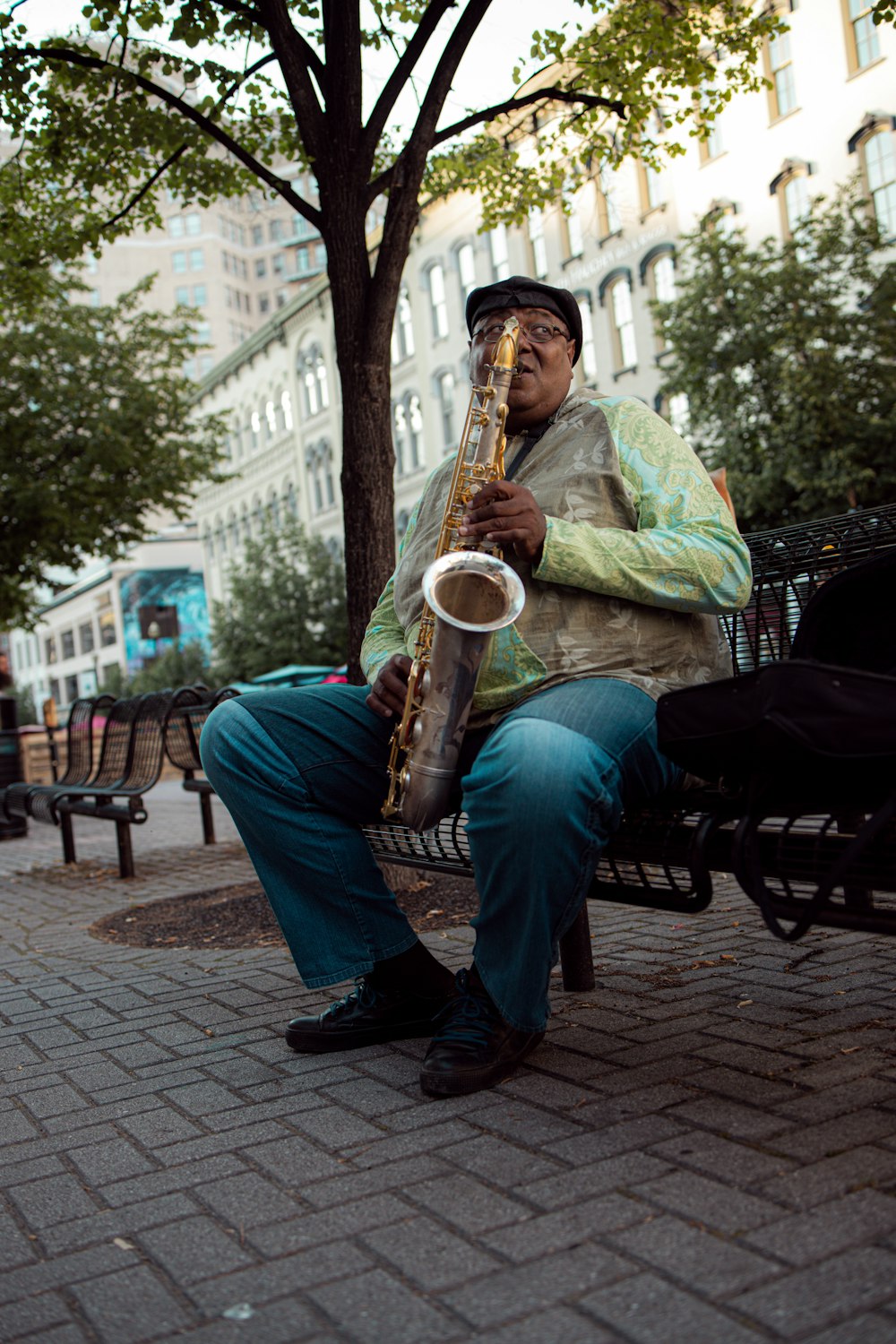 man in green dress shirt playing saxophone