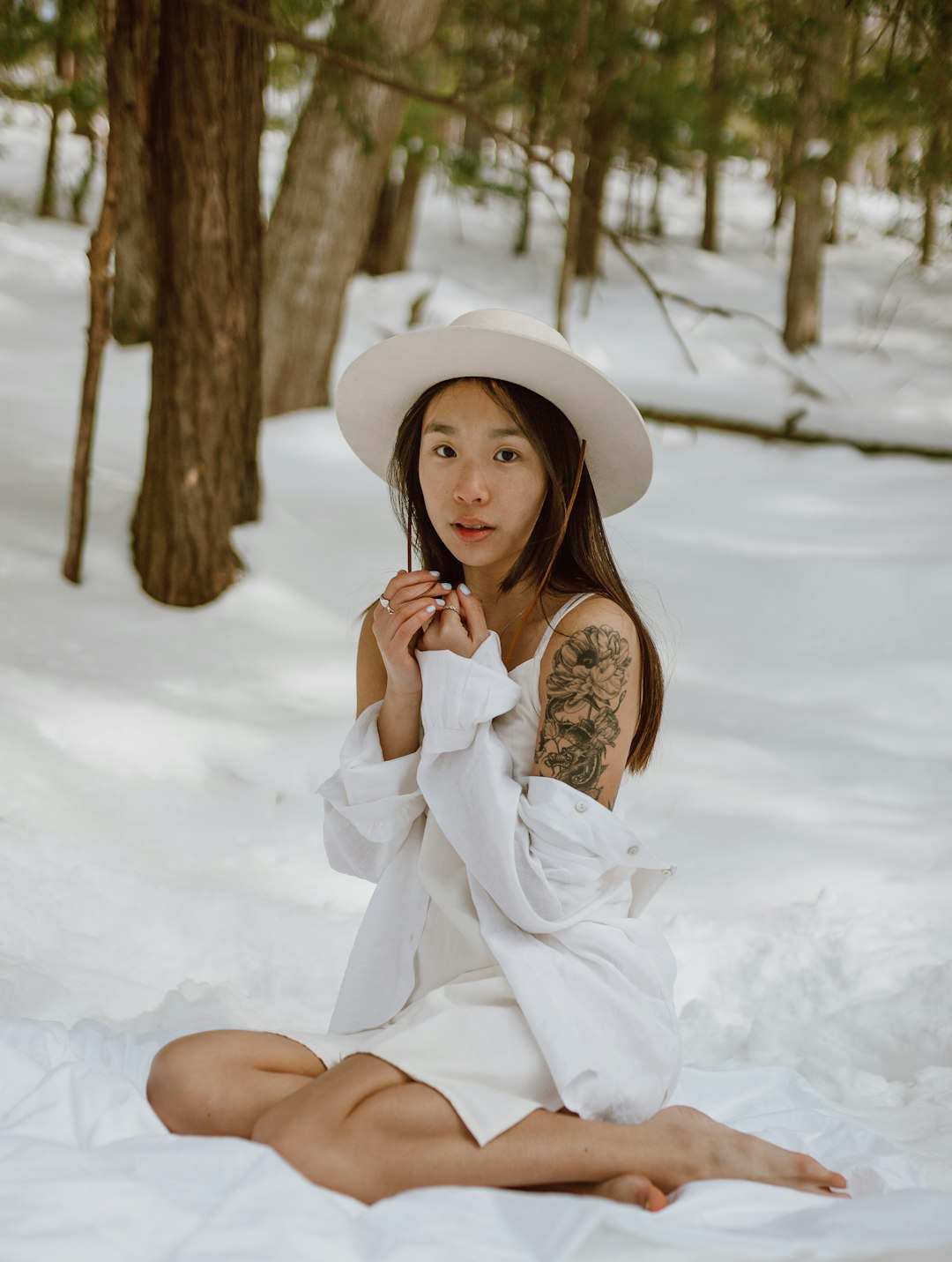 woman in white dress sitting on snow covered ground during daytime