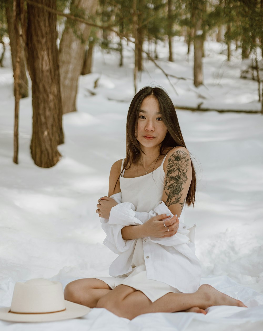 woman in white dress sitting on snow covered ground during daytime