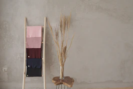 brown broom leaning on white wall