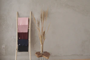 brown broom leaning on white wall