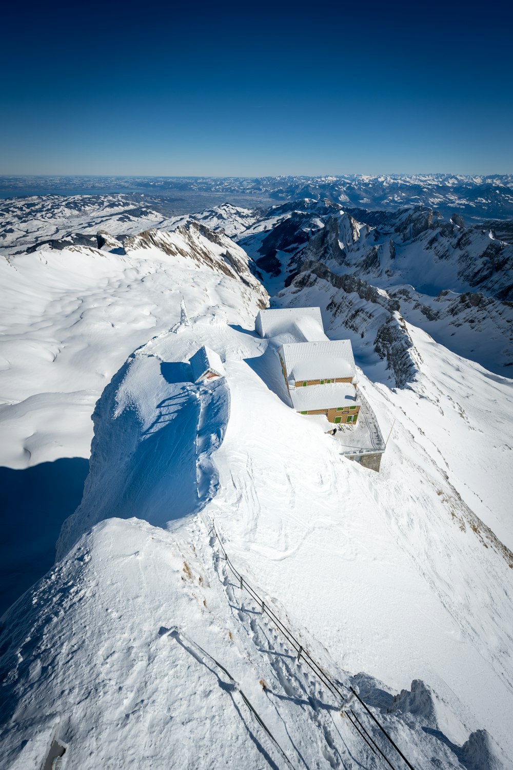white and brown house on snow covered mountain during daytime