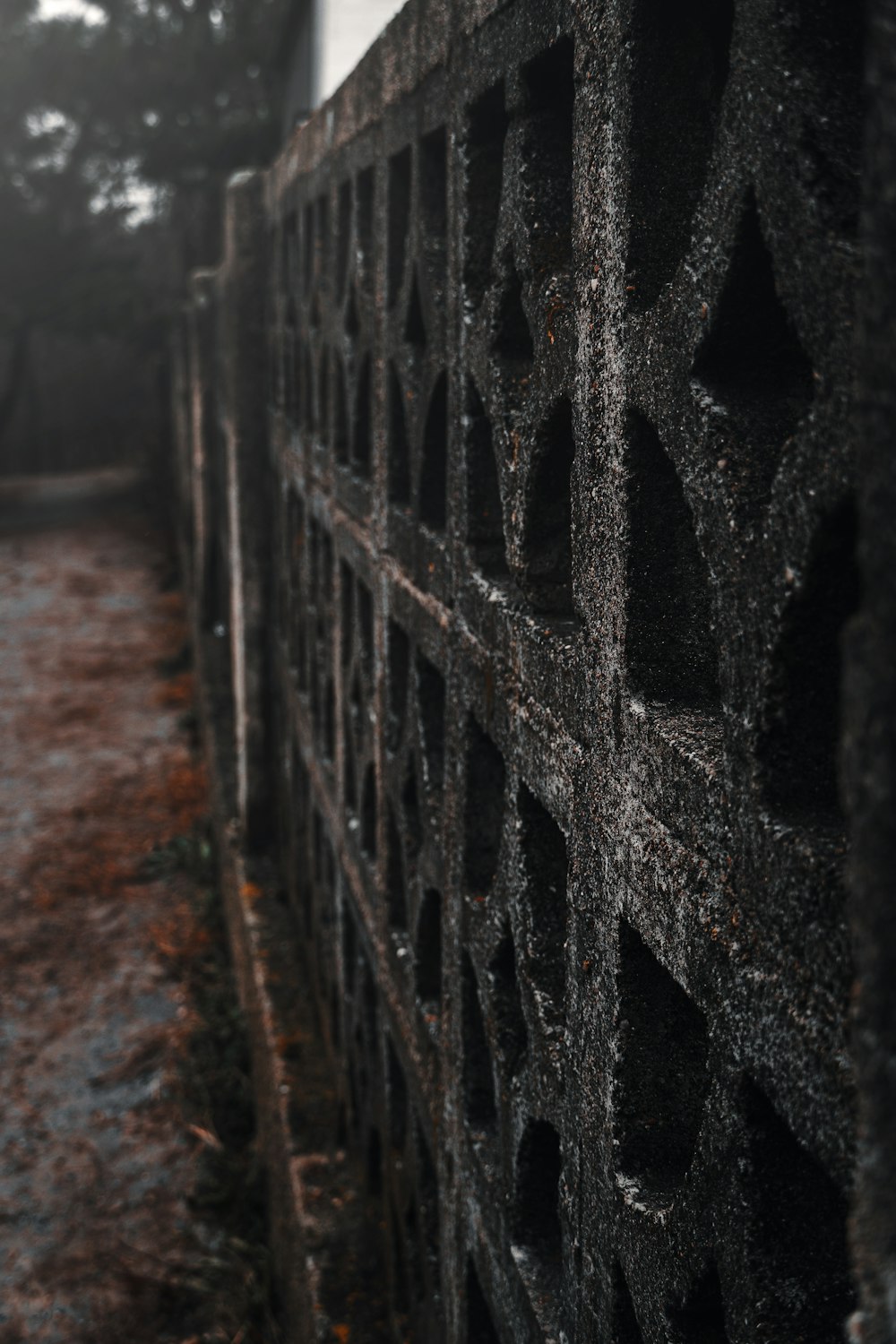 black metal fence on brown dirt road