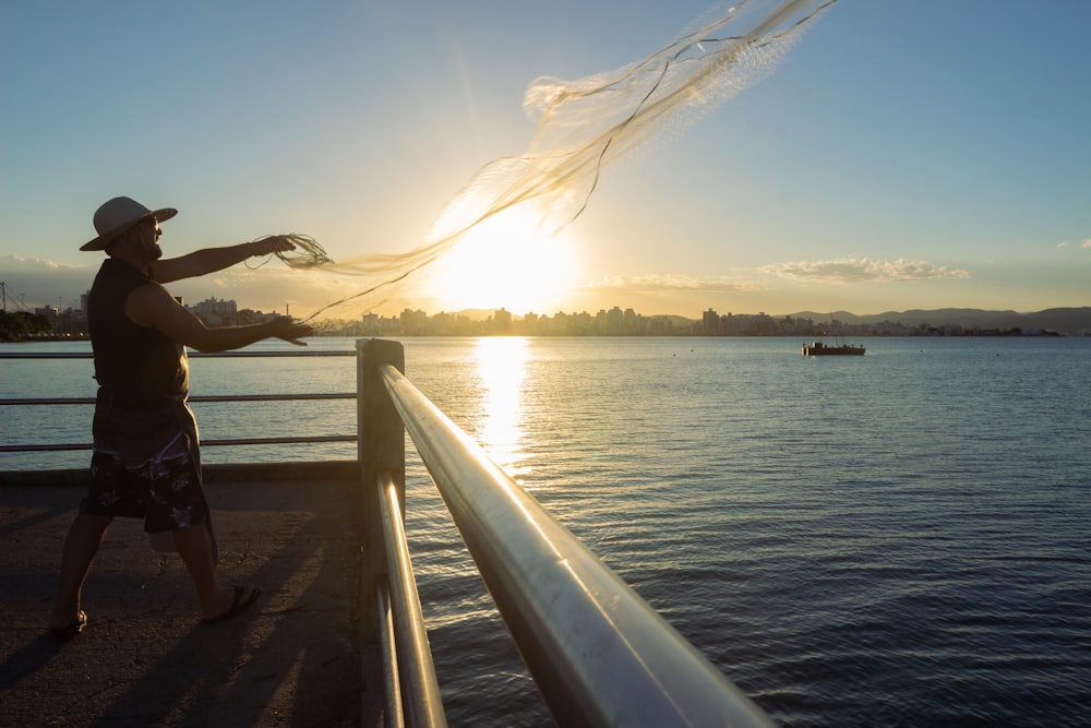 person in black jacket standing on brown wooden dock during daytime