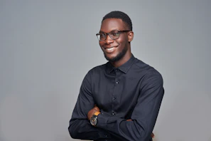 man in black dress shirt wearing black framed eyeglasses