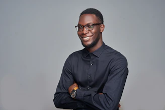 man in black dress shirt wearing black framed eyeglasses