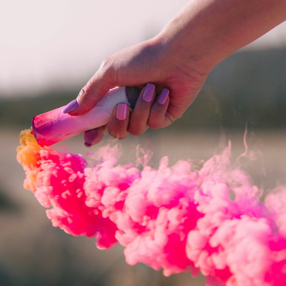 person holding pink and yellow powder