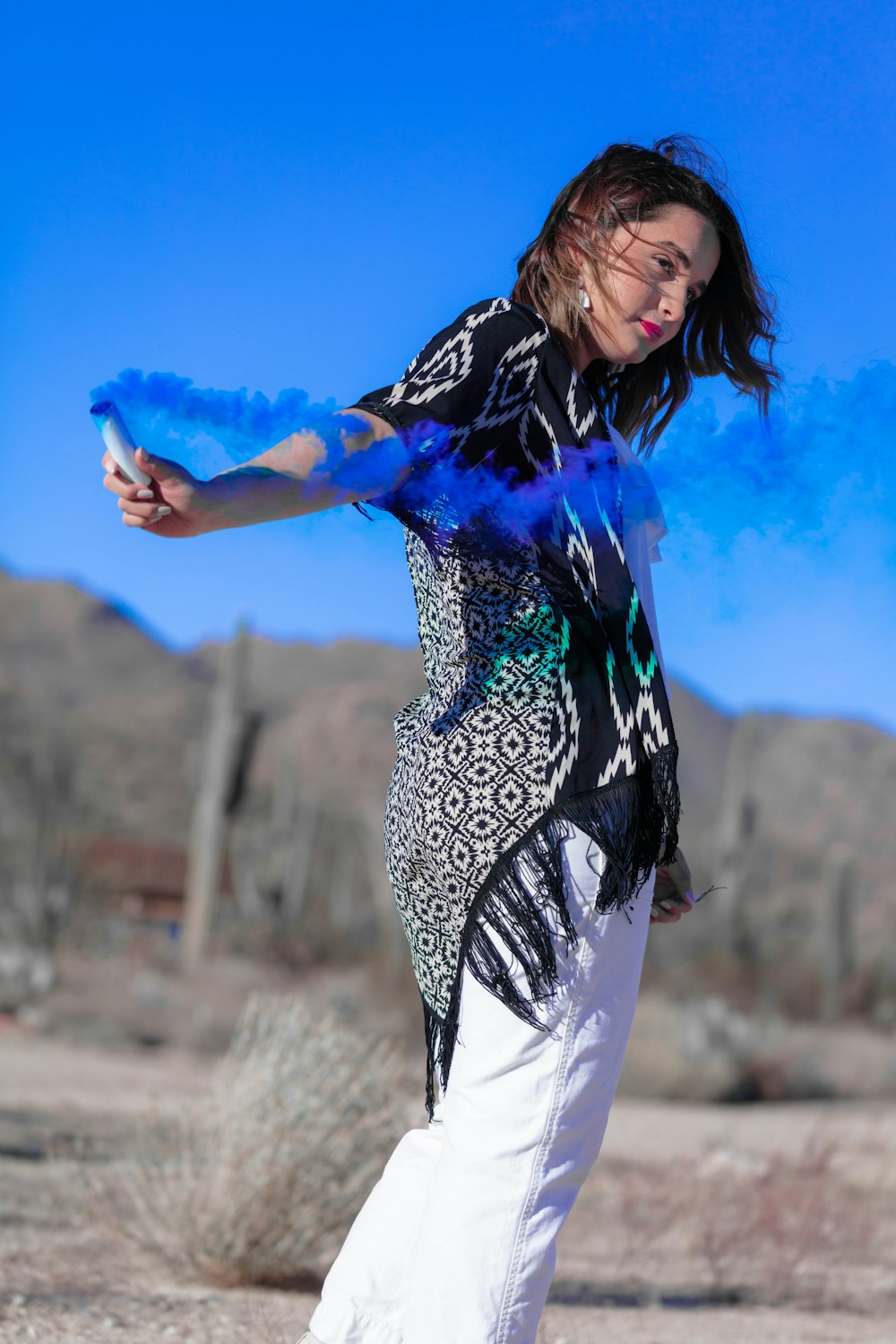 woman in blue and white floral dress standing on brown field during daytime