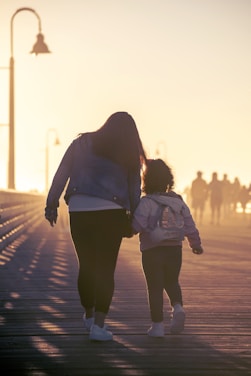 mother and child walking on the road at dusk