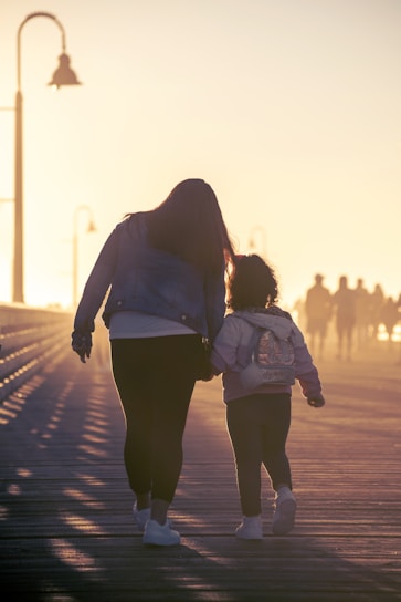 mother and child walking on the road at dusk