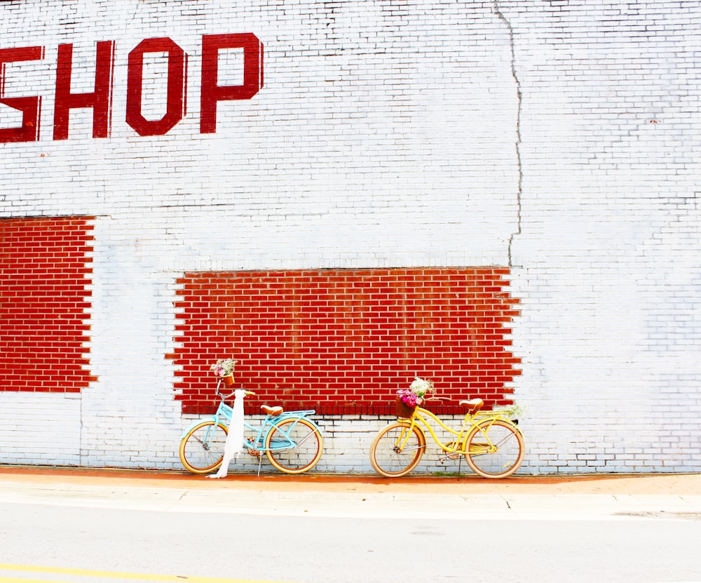 white bicycle parked beside white wall