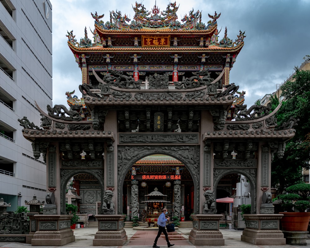 people walking on gray concrete pathway near brown and black temple during daytime