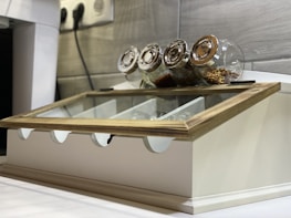 A tidy kitchen countertop featuring kitchen spice boxes arranged neatly in a row.