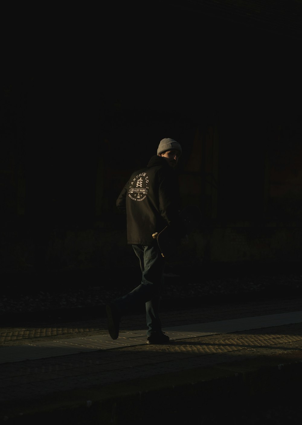 man in black coat walking on street during nighttime