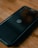 A smartphone lies on a wooden surface, displaying a logo resembling a 'W' inside a circle on its screen. The phone is encased in a protective cover.
