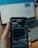 a person holding a cell phone in front of a laptop