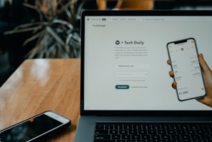 mac book encima de una mesa con un movil