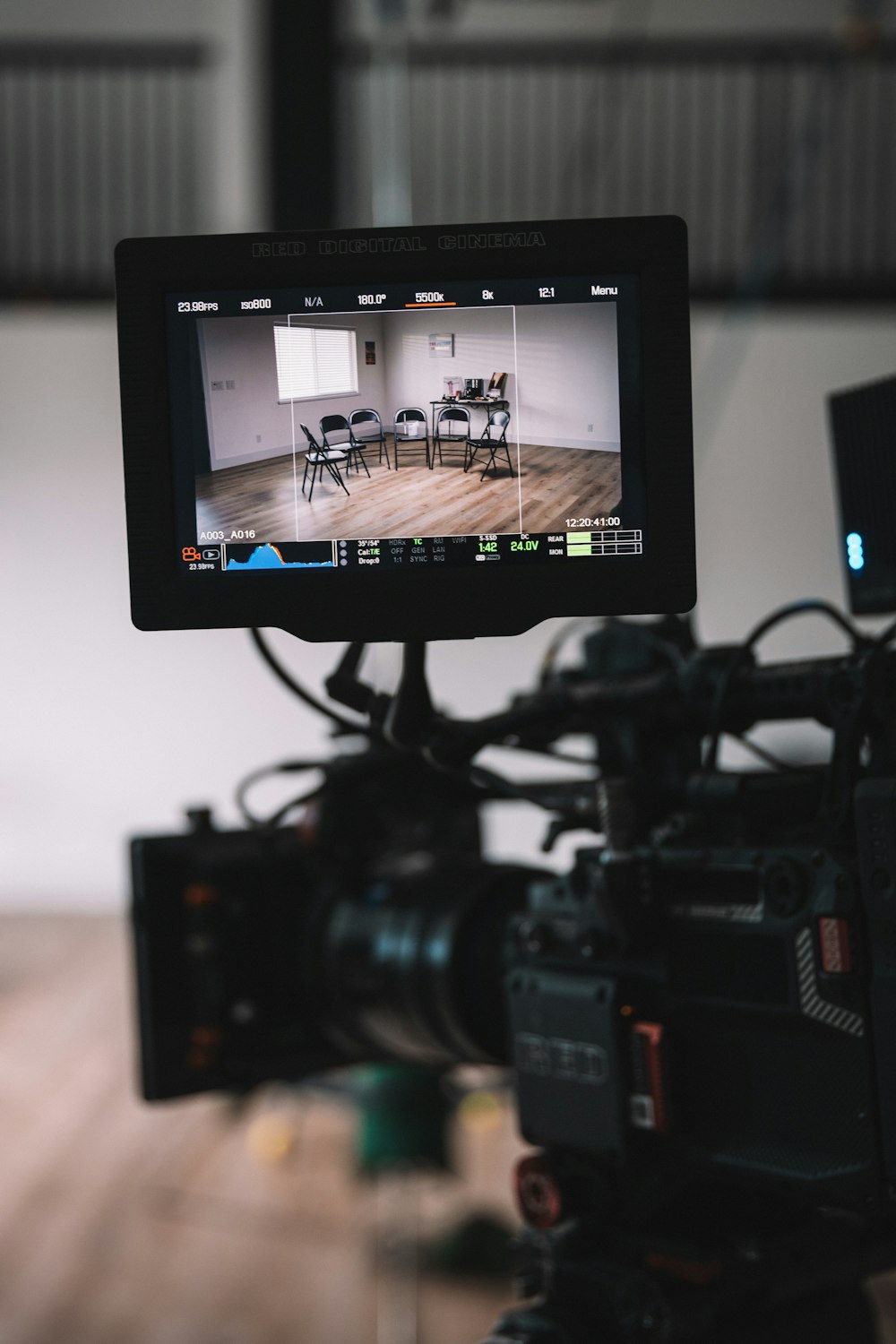 a video camera with chairs and a table in the background