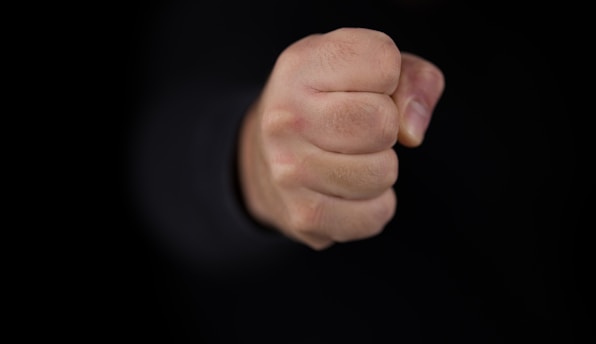 persons fist on black background