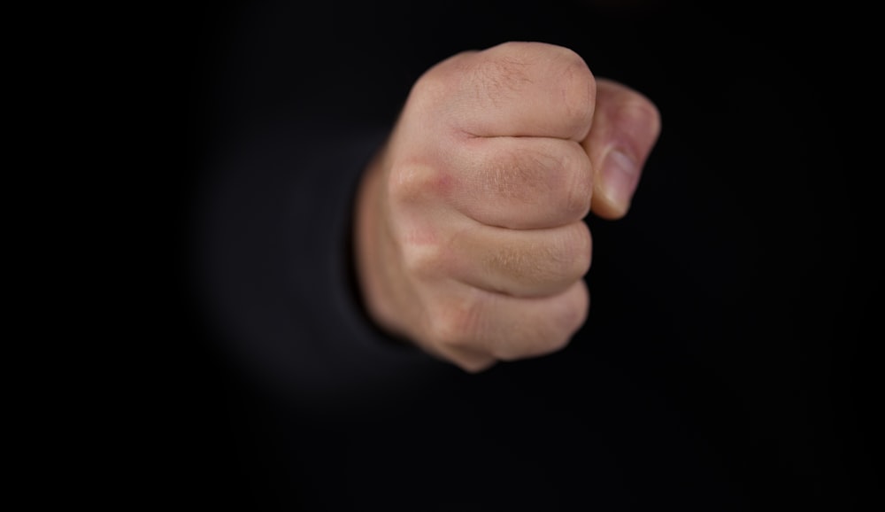 persons fist on black background