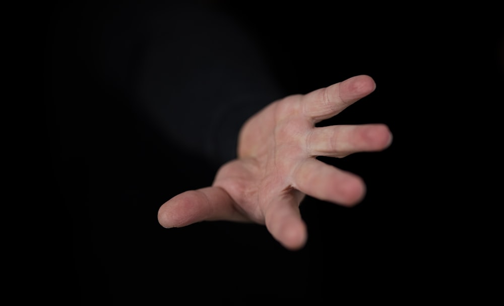 persons left hand with black background