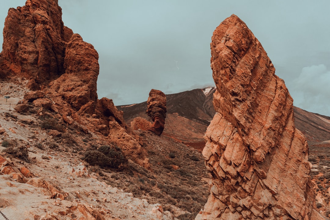 brown rock formation under white clouds during daytime