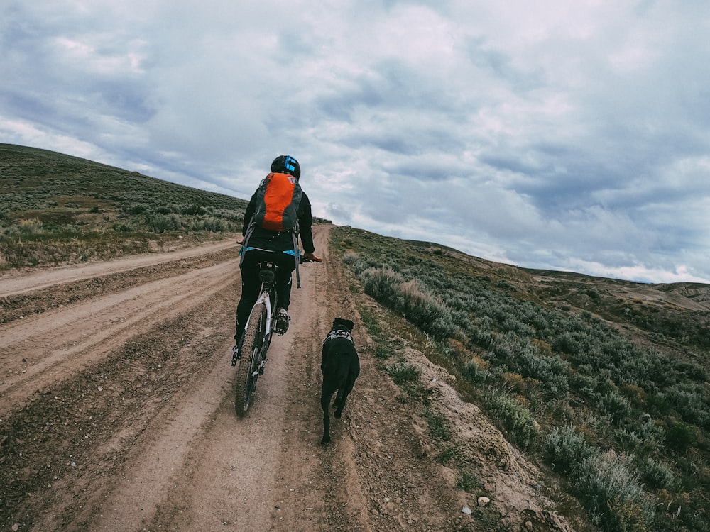 man in black jacket riding bicycle on road during daytime