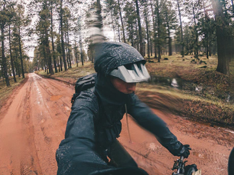 A sleek cyclist wearing Siroko gear riding through a misty forest trail at dawn.
