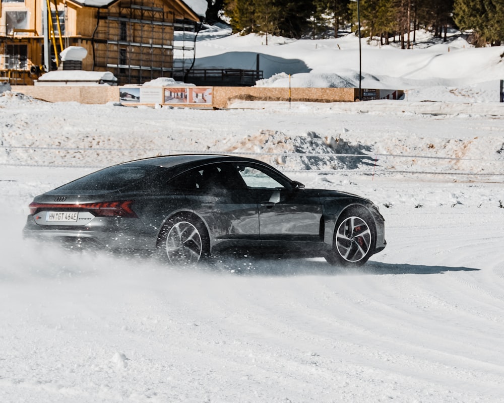 black coupe on snow covered road during daytime