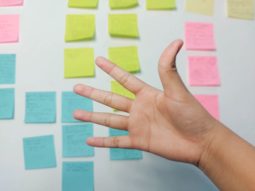 persons left hand with yellow sticky notes