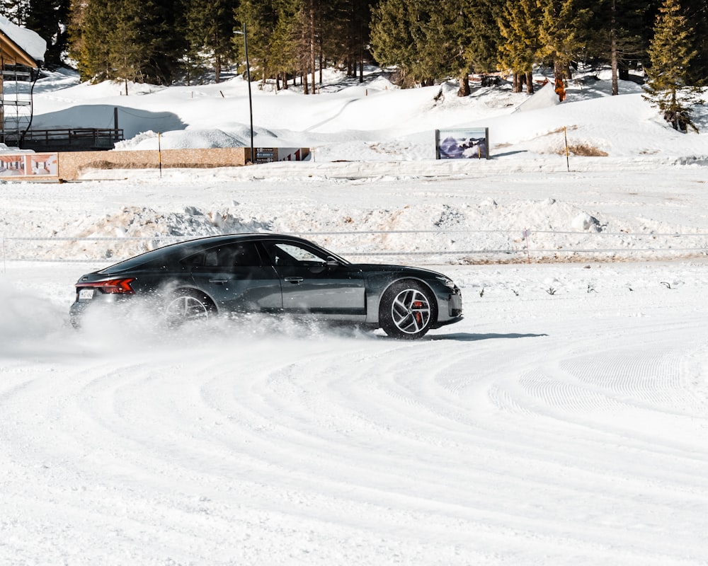 black coupe on snow covered road during daytime