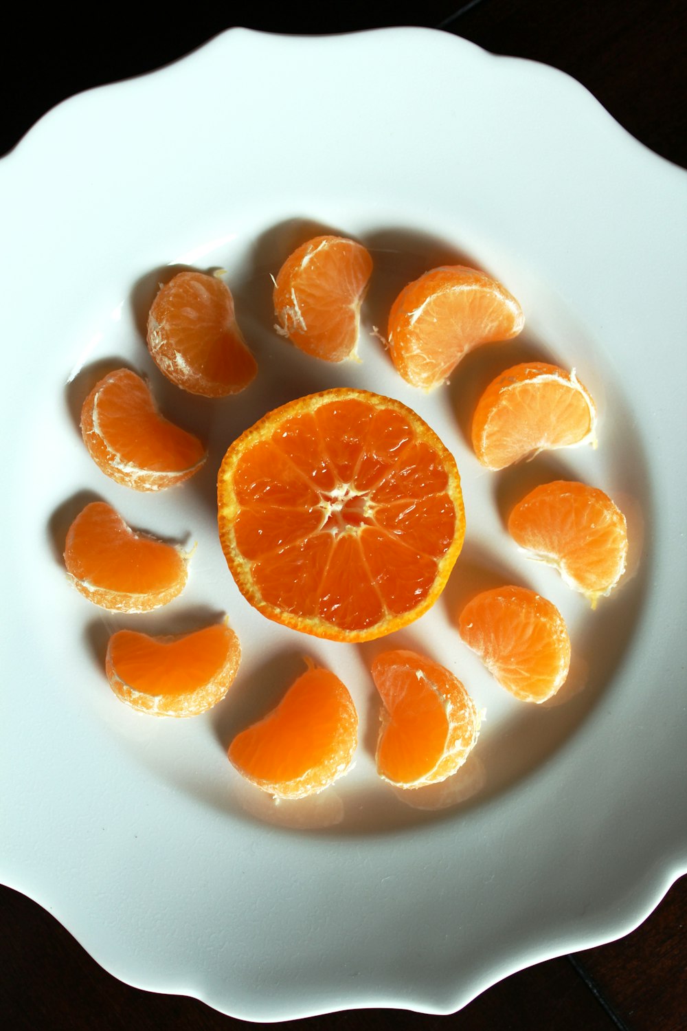 Frutas de naranja en rodajas en plato de cerámica blanca