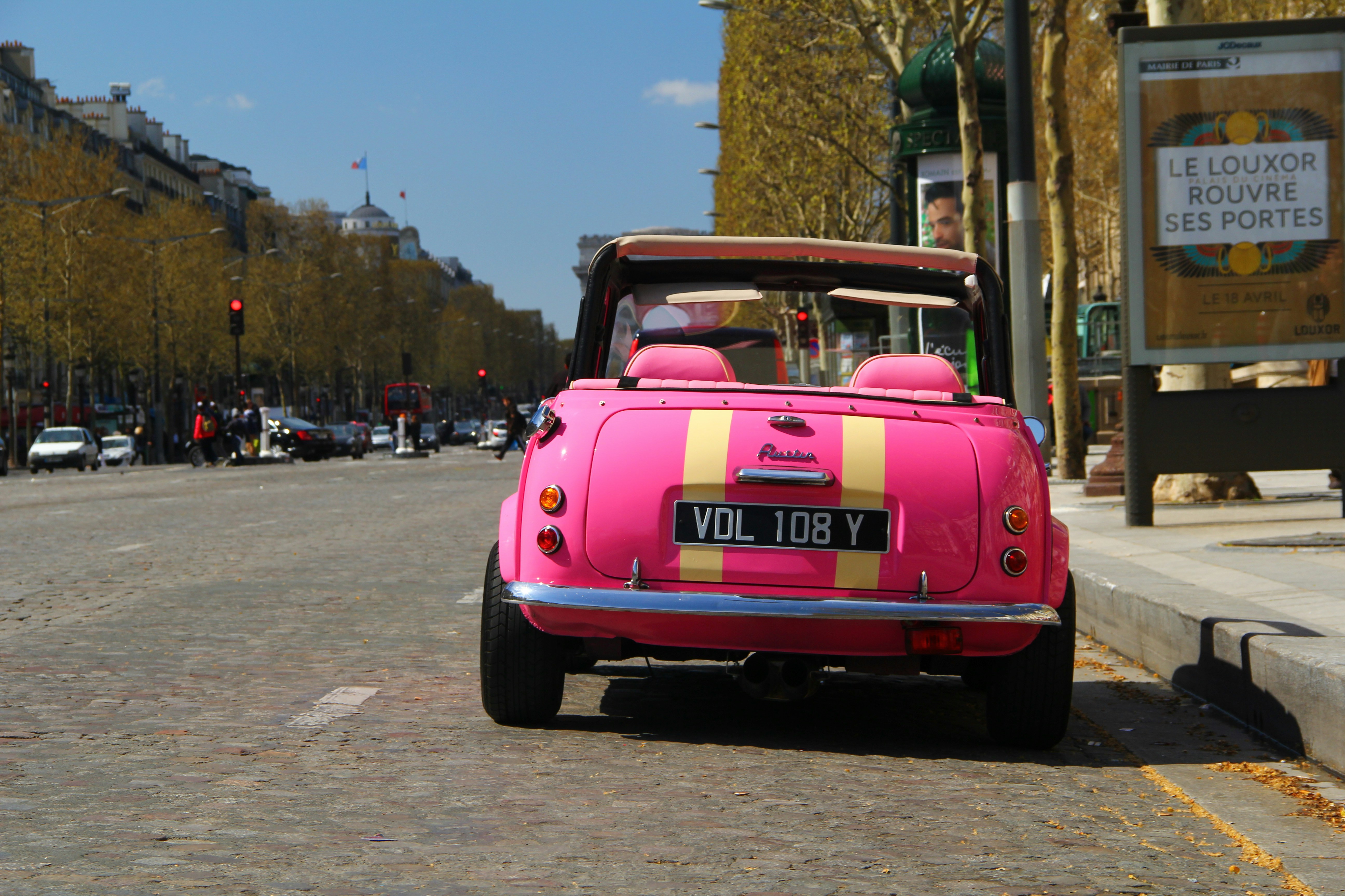 red chevrolet camaro on road during daytime, A pink convertible car in Paris France.