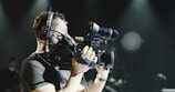man in black shirt holding black dslr camera