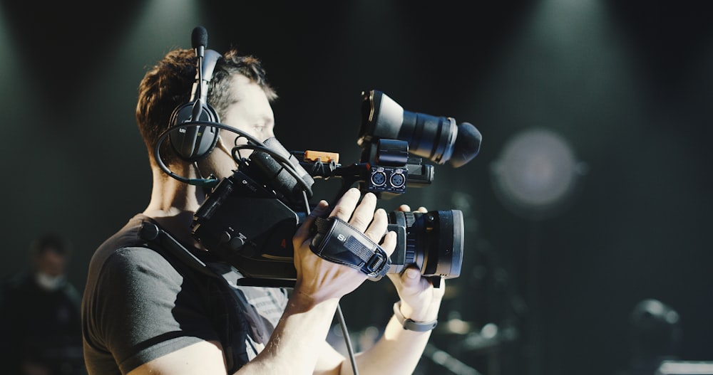 man in black shirt holding black dslr camera