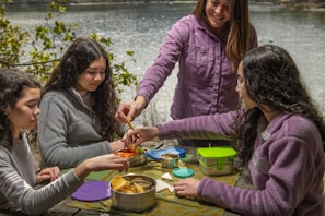 A group of friends enjoying perogies at a picnic table.