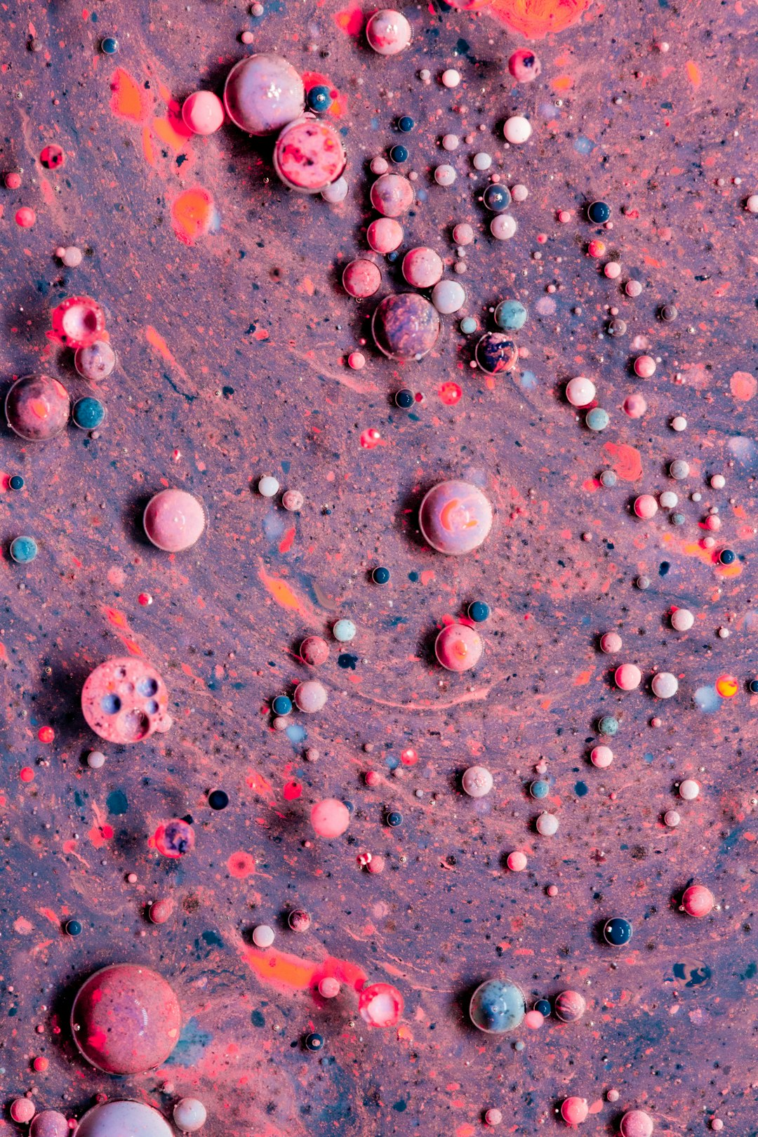 pink and white round beads on gray surface