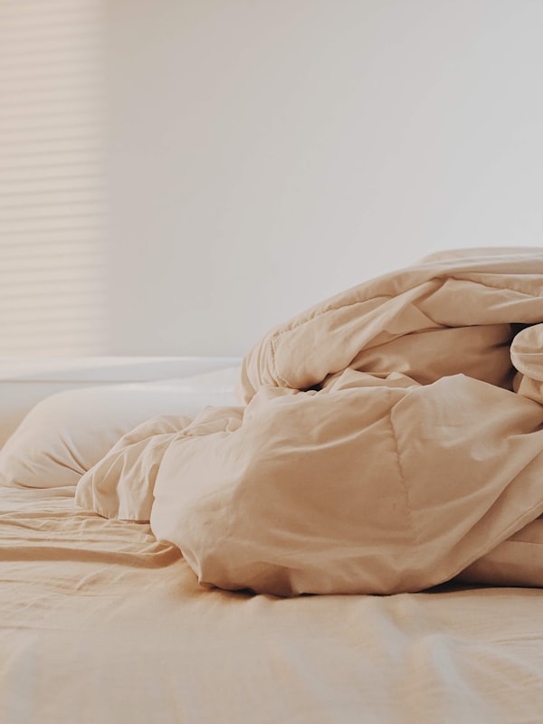 White bed linen and comforter on a neatly styled bed