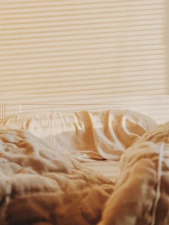 Close-up of a freshly cleaned mattress with sunlight streaming through a window.