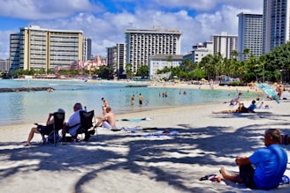 A vibrant photo of tourists enjoying a sunny beach in Bali with clear blue skies.