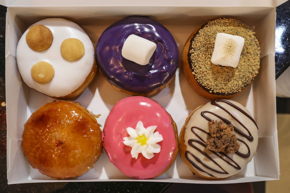 Rosquillas marrones y rosadas en bandeja blanca