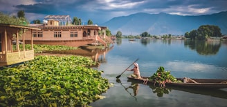 man in red shirt riding on brown boat on lake during daytime
