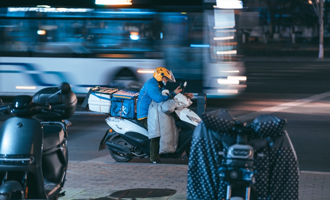 man in blue jacket and black helmet riding on blue motorcycle