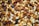 A close-up view of a mixture of nuts and dried fruits. The image includes almonds, walnuts, raisins, cashews, and various other seeds and nuts, with a rich, varied texture.